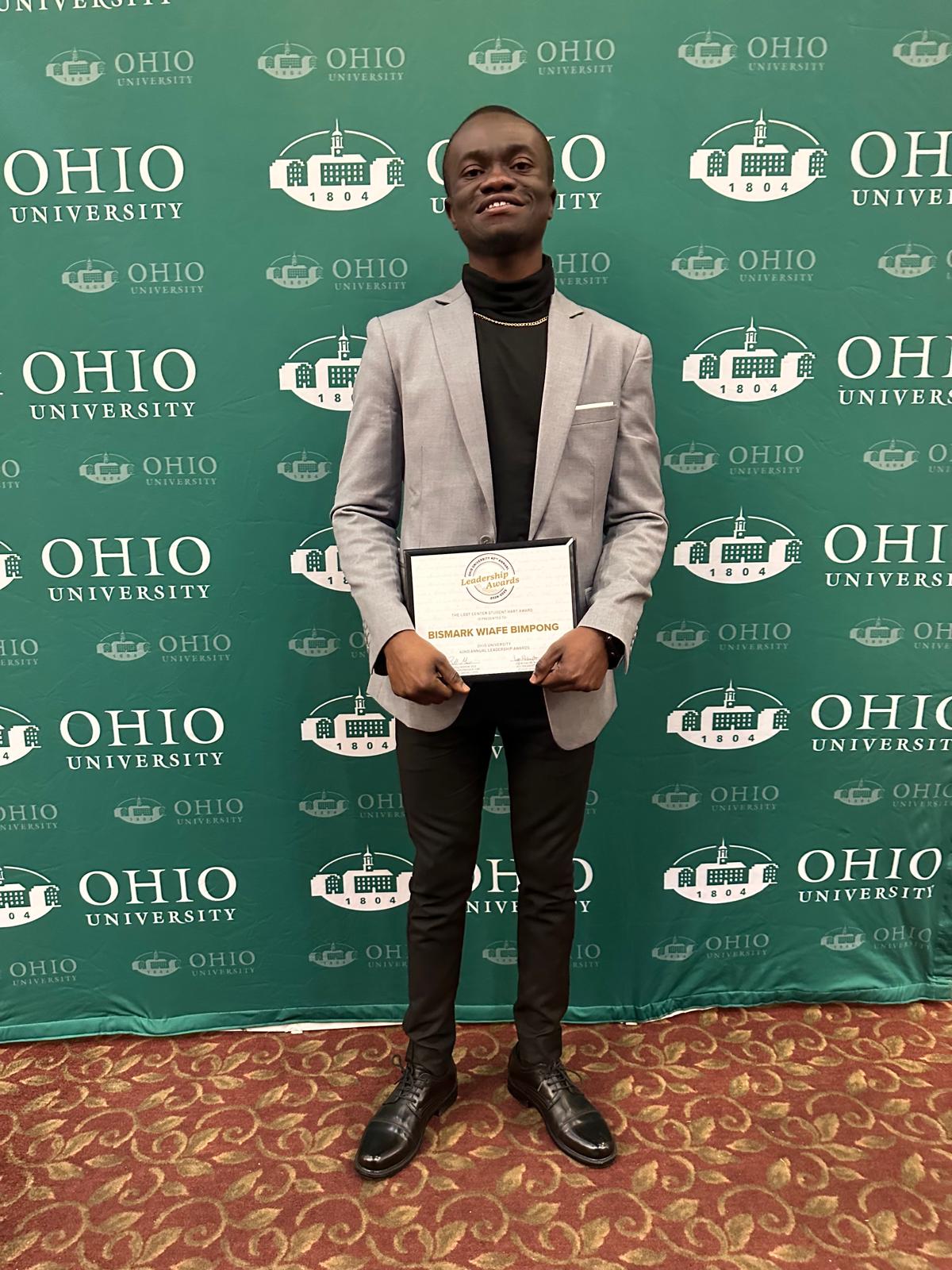 Bismark holding a leadership award at Ohio University